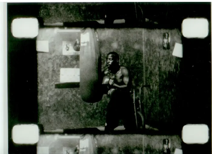 Ein schwarzer Mann boxt gegen einen Boxsack