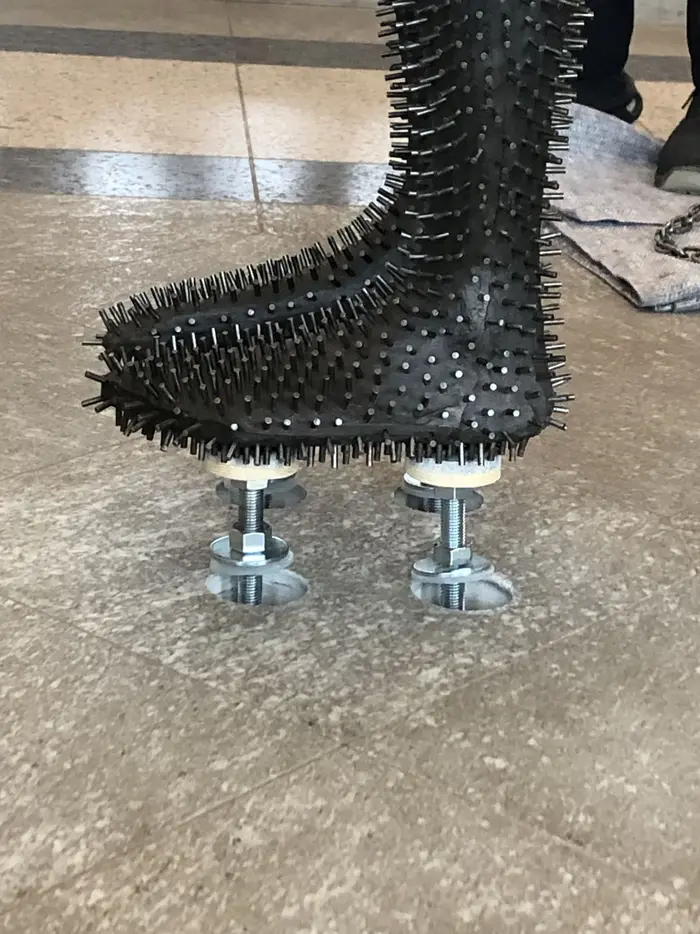 Zu sehen ist das Werk "Under my Skin" von Antony Gormley aus dem Jahr 1997, einem in Eisen ausgeführten einstigen Abgusses des Künstlers. Es ist gänzlich von stacheligen Eisenstiften überzogen. Auf dem Foto wird es liegend vorbereitet um in der antikenhalle installiert zu werden.