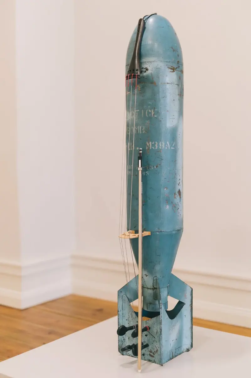 Zu sehen ist eine Bombenhülle, die zu einem Cello umgebaut, für Performances genutzt wurde.
