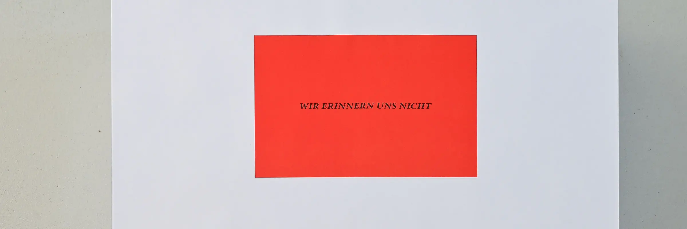 Auf einem Poster steht auf rotem Grund der Satz "Wir erinnern uns nicht". Das Werk gehört zu einer wichtigen Riehe des Künstlers Felix Gonzalez-Torres.