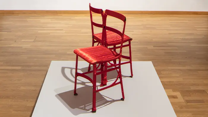 Zwei rote miteinander verschlungene Stühle