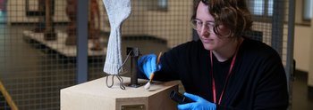 Restauratorin Franziska Klinkmüller beim Entstauben des Sockels eines Readymade von Georg Herold