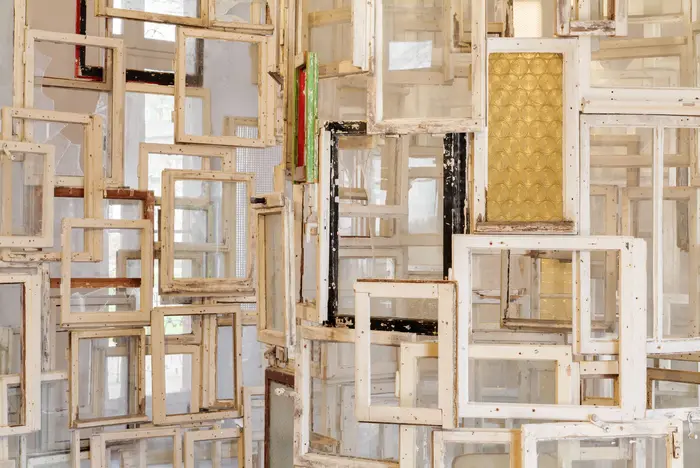 Zu sehen ist ein Detail des Werks "Inside-Outside" der Künstlerin Chiharu Shiota aus dem Jahr 2009. Die begehbare Installation besteht aus Altbaufenstern, die die Künstlerin in Ost-Berlin zusammengetragen und meterhoch spiralförmig angeordnet hat. In der Mitte steht ein Stuhl auf dem man von innen nach außen schauen kann.