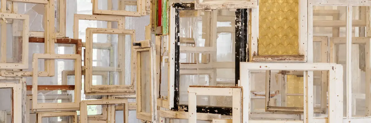 Zu sehen ist ein Detail des Werks "Inside-Outside" der Künstlerin Chiharu Shiota aus dem Jahr 2009. Die begehbare Installation besteht aus Altbaufenstern, die die Künstlerin in Ost-Berlin zusammengetragen und meterhoch spiralförmig angeordnet hat. In der Mitte steht ein Stuhl auf dem man von innen nach außen schauen kann.