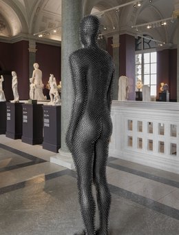 Rückenansicht einer Figur mit schwarzen Stacheln