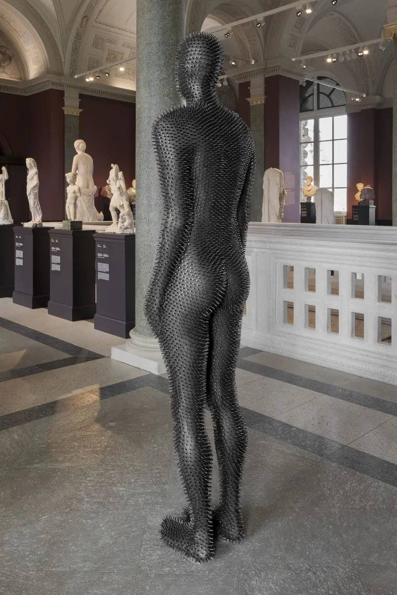 Rückenansicht einer Figur mit schwarzen Stacheln